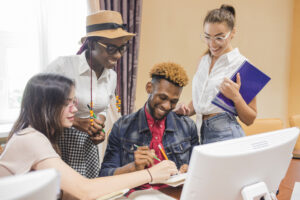 Young Nigerian graduates searching for entry-level job opportunities on a laptop.